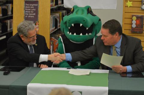 Sage President Christopher Ames shakes hands with East Greenbush Central School District Superintendent Jeffrey Simons during their announcement of an Early Assurance Agreement between the two schools.